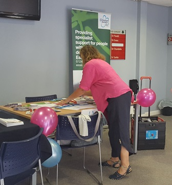 A representative at the Carer's event putting leaflets out on a table